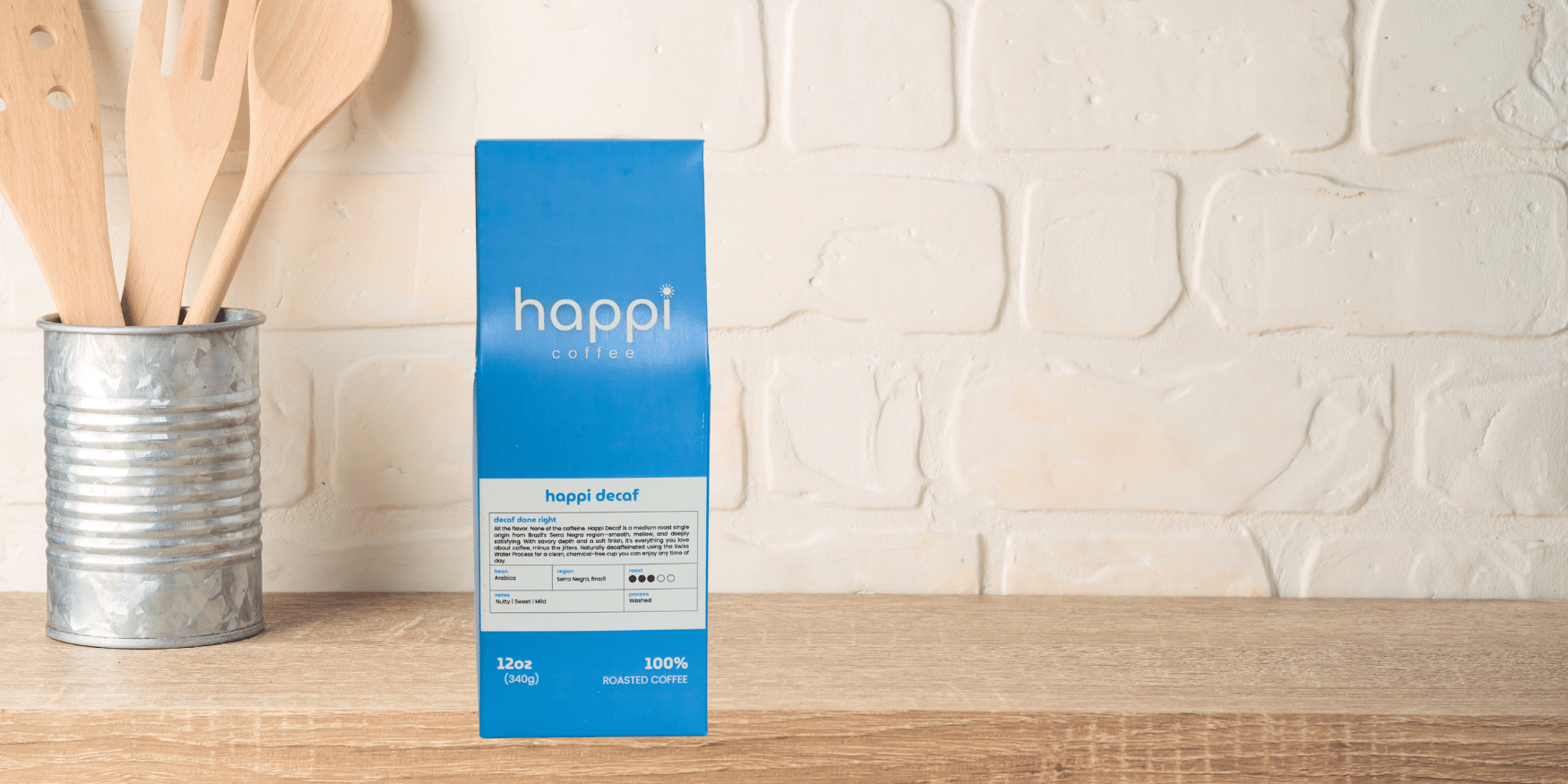 Lineup of 12 oz bags of Happi Decaf. Medium Roast Decaffeinated Coffee with Nutty, Sweet & Mild Flavor, Available Ground or Whole Bean