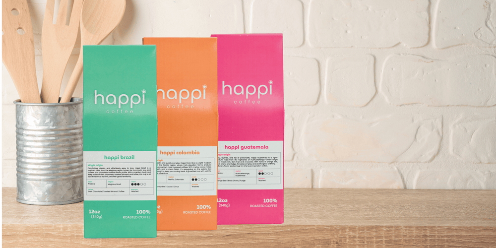 Fresh-roasted single origin coffee from Happi Coffee—Brazil, Colombia, and Guatemala bags on a kitchen counter.