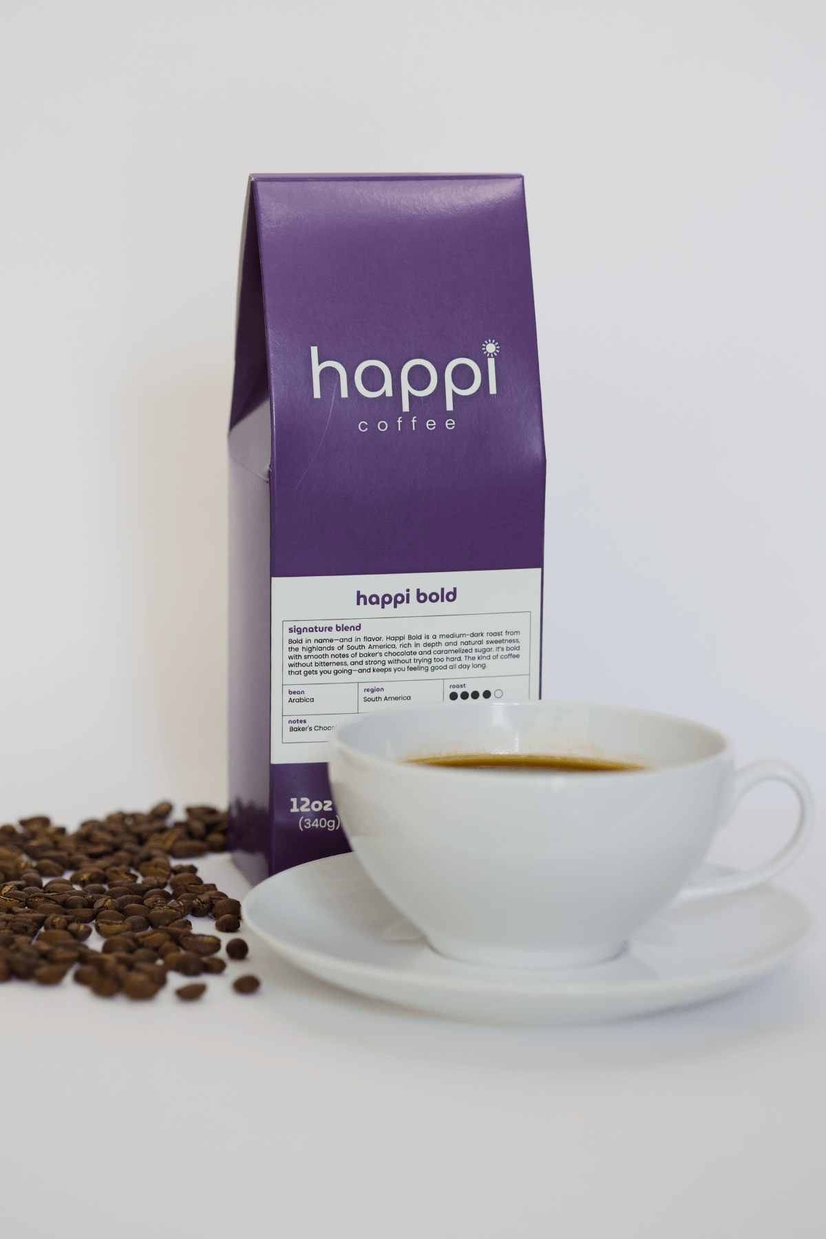 12 oz bag of happi bold dark roast specialty coffee with scattered beans and brewed coffee in white cup