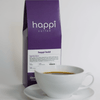 12 oz bag of happi bold dark roast specialty coffee with brewed coffee in a white cup and saucer