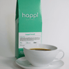 12 oz bag of happi brazil medium roast specialty coffee with brewed coffee in a white cup and saucer
