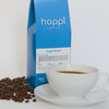 12 oz bag of happi decaf medium roast specialty coffee with scattered beans and brewed coffee in white cup
