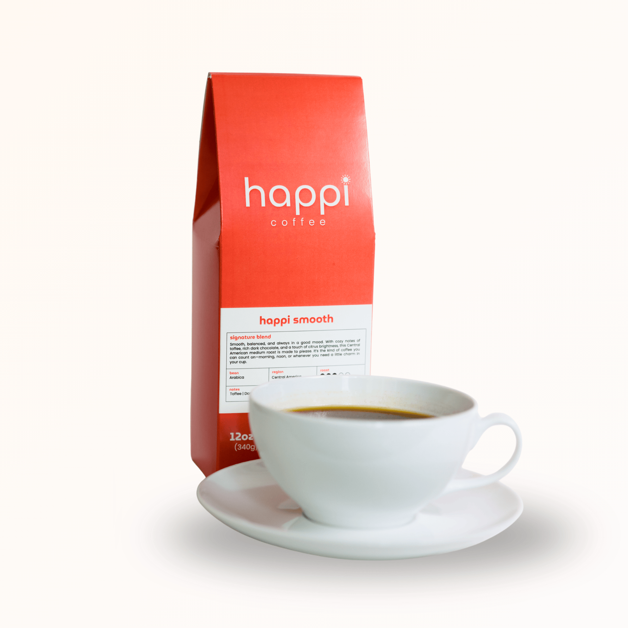 Side view of 12 oz bag of Happi Smooth with a cup of coffee. Best Medium Roast Coffee Beans with Cozy Sweetness & Balanced Flavor, Available Ground or Whole Bean