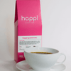 12 oz bag of happi guatemala light roast specialty coffee with brewed coffee in a white cup and saucer