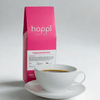 View of 12 oz bag of happi guatemala light roast coffee next to a cup of coffee – available in whole bean or ground